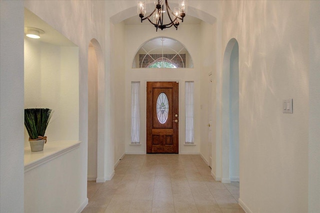 6604 Donner Cv, Austin, TX 78749 - entryway with a chandelier, a towering ceiling, light tile patterned floors, and arched walkways