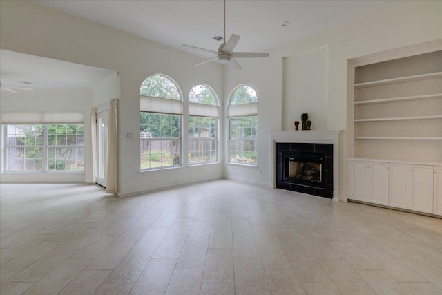6604 Donner Cv, Austin, TX 78749 - unfurnished living room featuring ceiling fan, a tile fireplace, and built in shelves