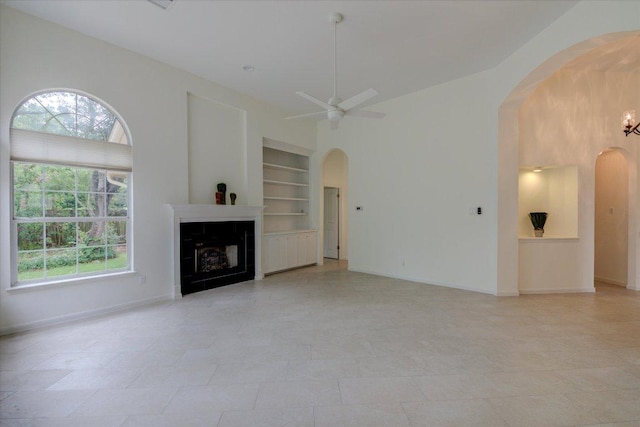 6604 Donner Cv, Austin, TX 78749 - unfurnished living room with arched walkways, built in features, and plenty of natural light