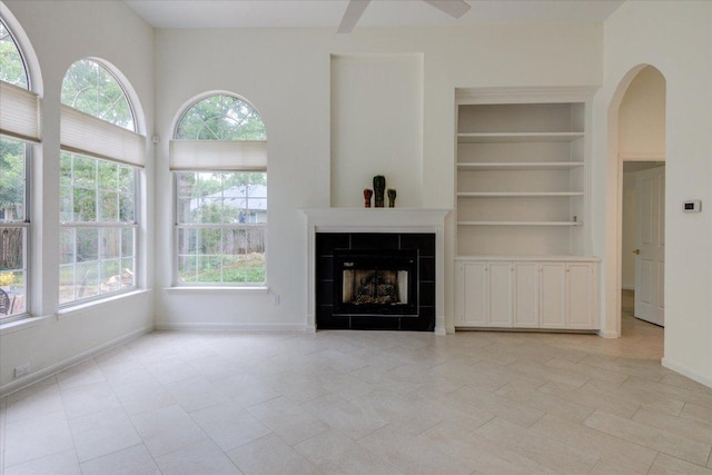 6604 Donner Cv, Austin, TX 78749 - unfurnished living room featuring plenty of natural light, built in features, a ceiling fan, and a tile fireplace