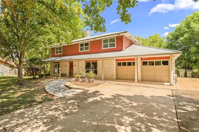 510 Sendero Verde St, Manchaca, TX 78652 - traditional home with driveway, an attached garage, covered porch, a metal roof, and a chimney