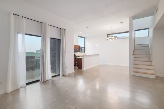 5912 Toscana Ave, Austin, TX 78724 - unfurnished living room with a chandelier, finished concrete flooring, and stairway