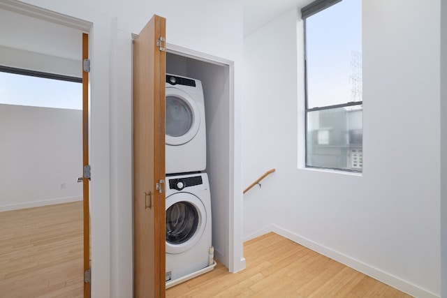 5912 Toscana Ave, Austin, TX 78724 - washroom featuring stacked washer and clothes dryer, light wood-style flooring, and healthy amount of natural light