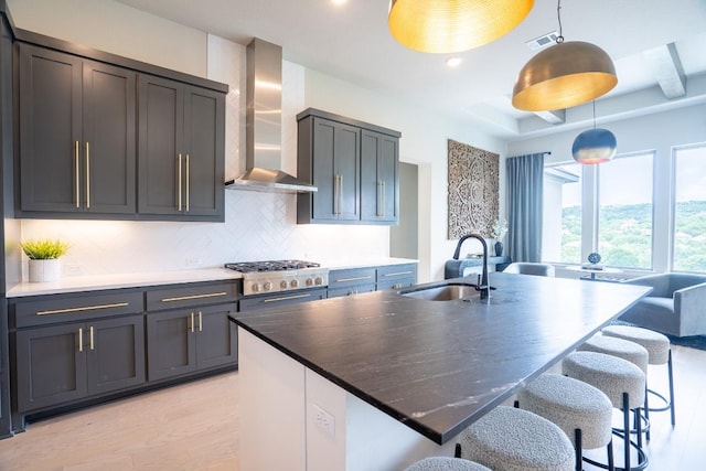 2220 Normandy Vw, Leander, TX 78641 - kitchen featuring wall chimney range hood, pendant lighting, stainless steel gas cooktop, decorative backsplash, and light wood-type flooring
