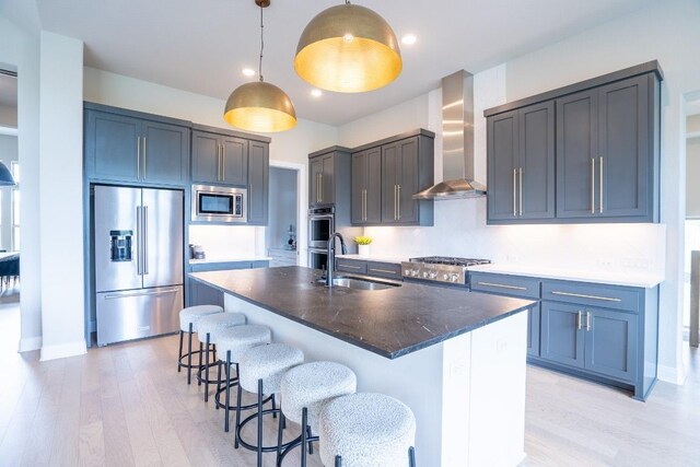 2220 Normandy Vw, Leander, TX 78641 - kitchen with stainless steel appliances, wall chimney range hood, light wood-style floors, a kitchen breakfast bar, and pendant lighting