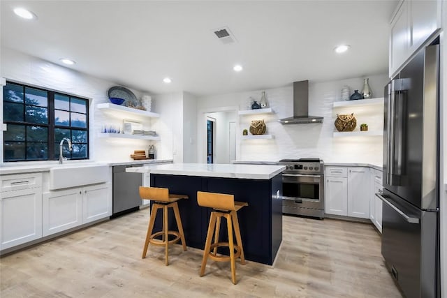 6569 Cutoff Rd, Round Top, TX 78940 - kitchen with appliances with stainless steel finishes, open shelves, wall chimney range hood, and recessed lighting