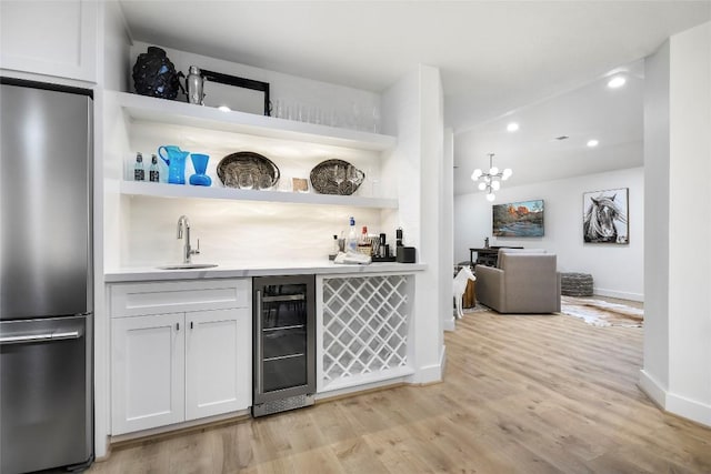 6569 Cutoff Rd, Round Top, TX 78940 - indoor wet bar featuring stainless steel fridge, beverage cooler, light wood finished floors, and recessed lighting