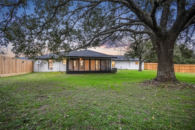 6569 Cutoff Rd, Round Top, TX 78940 - back of house at dusk featuring a sunroom and a fenced backyard