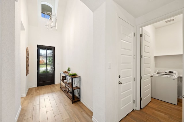 1535 Terrys Gate, New Braunfels, TX 78132 - foyer entrance with washer / dryer, light wood-type flooring, and a chandelier