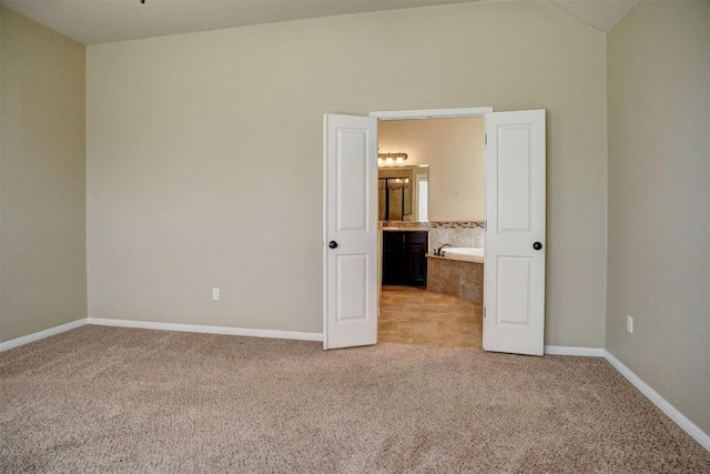 285 Chisholm Trl, Bastrop, TX 78602 - unfurnished bedroom with light carpet, vaulted ceiling, and connected bathroom