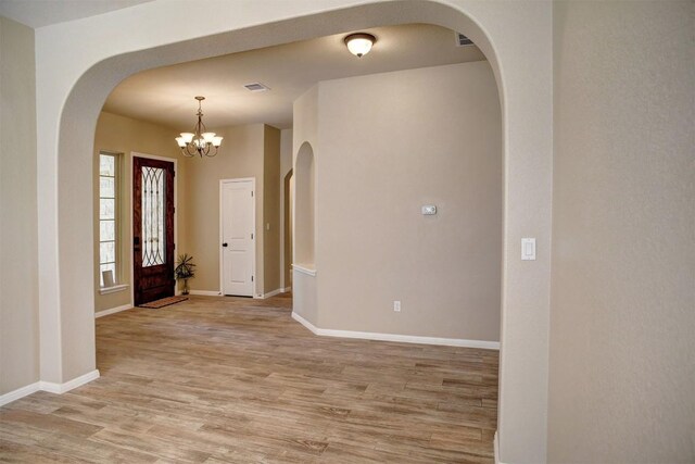 285 Chisholm Trl, Bastrop, TX 78602 - entrance foyer with light wood finished floors, a chandelier, and arched walkways