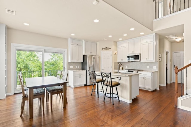 11400 W Parmer Ln Unit 75, Cedar Park, TX 78613 - kitchen featuring stainless steel appliances, tasteful backsplash, white cabinetry, a breakfast bar area, and recessed lighting