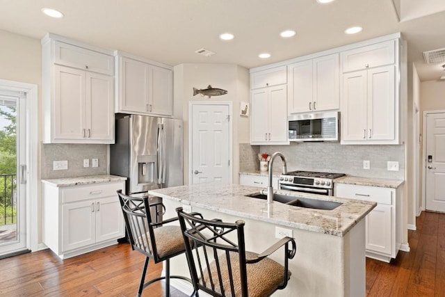 11400 W Parmer Ln Unit 75, Cedar Park, TX 78613 - kitchen with appliances with stainless steel finishes, hardwood / wood-style floors, white cabinetry, backsplash, and a kitchen island with sink