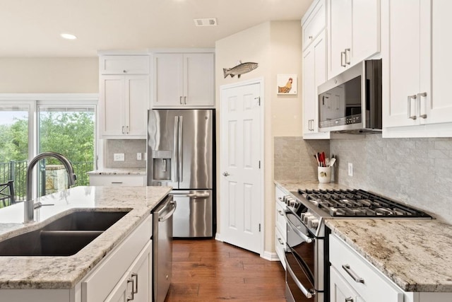 11400 W Parmer Ln Unit 75, Cedar Park, TX 78613 - kitchen featuring appliances with stainless steel finishes, dark wood-type flooring, white cabinetry, recessed lighting, and decorative backsplash