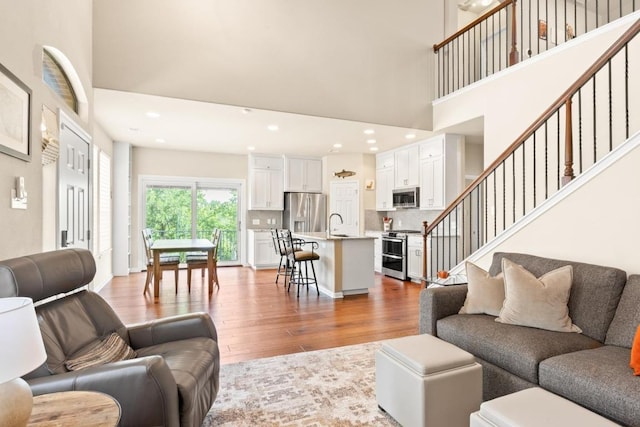 11400 W Parmer Ln Unit 75, Cedar Park, TX 78613 - living room with light wood-style flooring, a high ceiling, stairway, and recessed lighting
