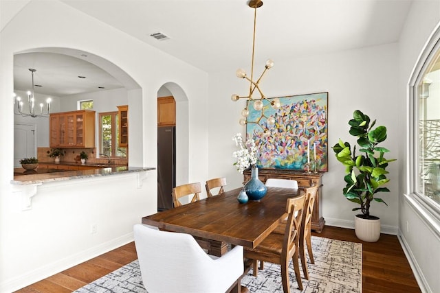 8540 Adirondack Trl Unit 21, Austin, TX 78759 - dining room with a chandelier, dark wood-type flooring, and arched walkways