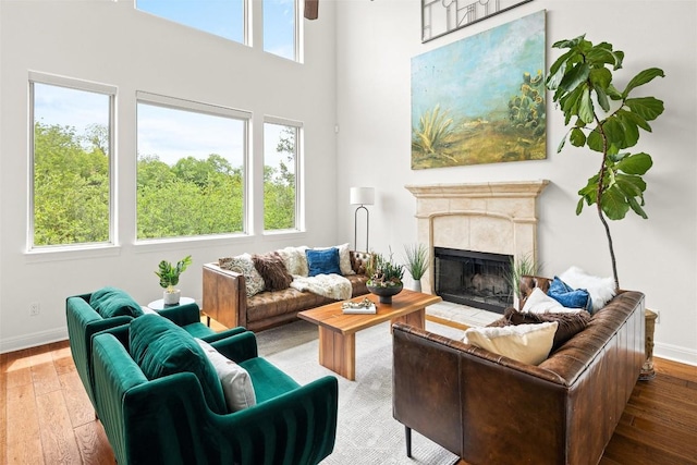 8540 Adirondack Trl Unit 21, Austin, TX 78759 - living area featuring wood-type flooring, a tiled fireplace, a high ceiling, and a ceiling fan