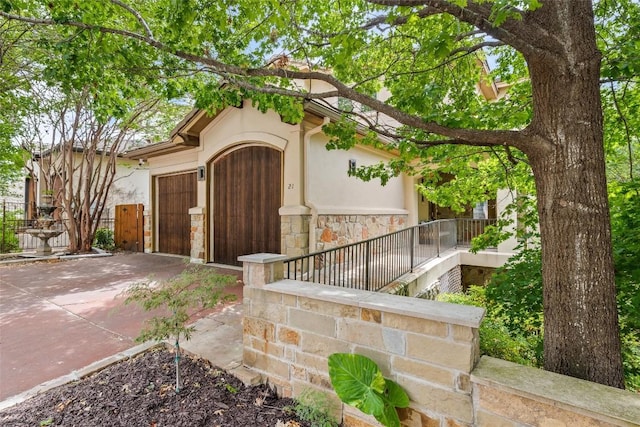 8540 Adirondack Trl Unit 21, Austin, TX 78759 - view of front of home featuring driveway, stucco siding, stone siding, and an attached garage