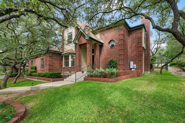125 Long Wood Ave, Lakeway, TX 78734 - view of front of home featuring brick siding, a front yard, and a chimney