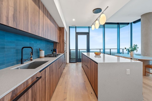 84 E Ave Unit 4004, Austin, TX 78701 - kitchen with modern cabinets, backsplash, a center island, gas stovetop, and brown cabinetry