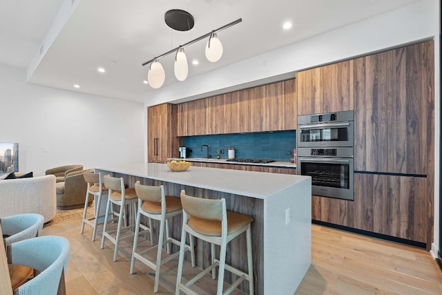 84 E Ave Unit 4004, Austin, TX 78701 - kitchen featuring gas stovetop, brown cabinets, modern cabinets, a breakfast bar, and light countertops