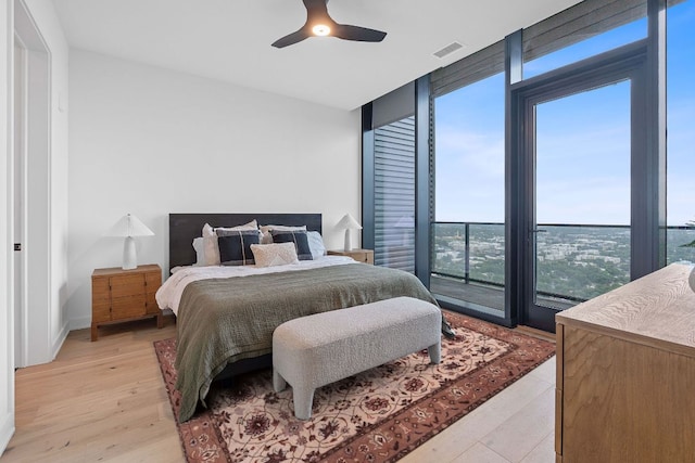 84 E Ave Unit 4004, Austin, TX 78701 - bedroom featuring light wood-type flooring, expansive windows, and a ceiling fan