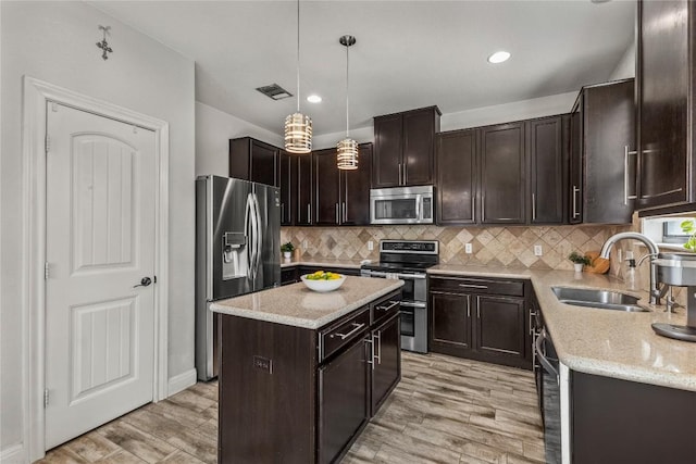 1231 Tumbleweed Trl, Temple, TX 76502 - kitchen featuring appliances with stainless steel finishes, dark brown cabinets, light wood finished floors, light stone countertops, and recessed lighting