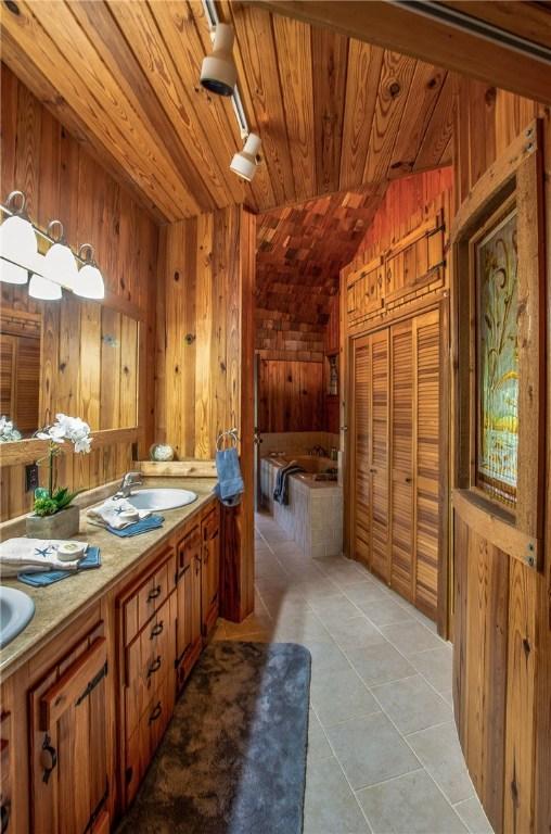 450 Oakwood Loop, San Marcos, TX 78666 - full bath featuring wooden ceiling, tile patterned flooring, double vanity, wooden walls, and a bath