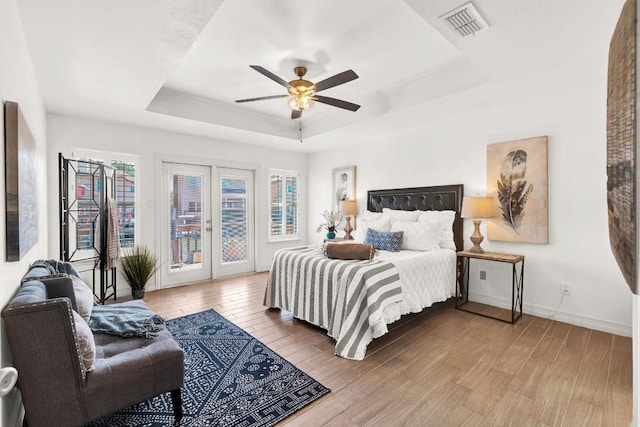 13517 Carlos Fifth Ct, Corpus Christi, TX 78418 - bedroom featuring a raised ceiling, access to outside, wood finished floors, and multiple windows