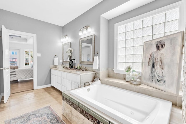 13517 Carlos Fifth Ct, Corpus Christi, TX 78418 - bathroom featuring connected bathroom, a whirlpool tub, double vanity, and wood finished floors