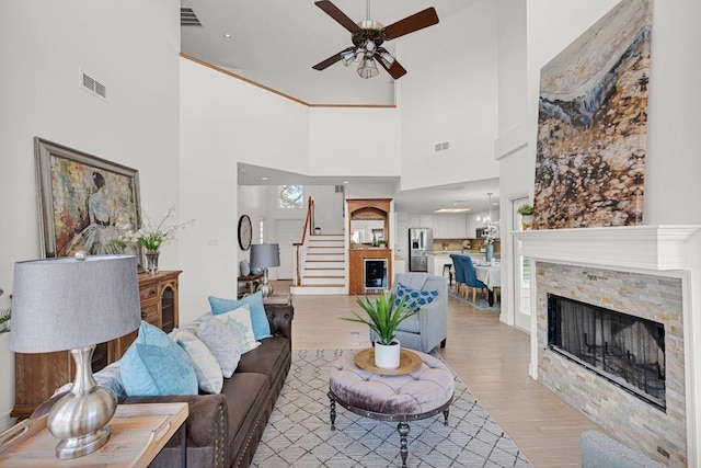 13517 Carlos Fifth Ct, Corpus Christi, TX 78418 - living room with wine cooler, ceiling fan, light wood-type flooring, a fireplace, and stairs