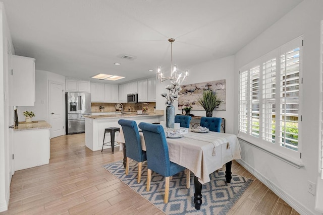13517 Carlos Fifth Ct, Corpus Christi, TX 78418 - dining area with a chandelier, light wood-style floors, and recessed lighting