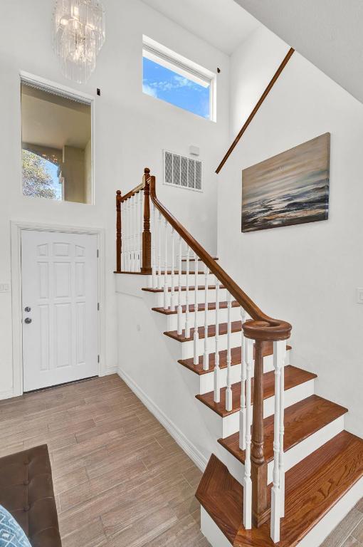 13517 Carlos Fifth Ct, Corpus Christi, TX 78418 - entrance foyer with stairs, wood finished floors, and a chandelier