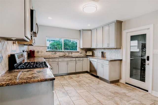 134 Sinclair St, Corpus Christi, TX 78411 - kitchen with appliances with stainless steel finishes, dark stone countertops, decorative backsplash, and gray cabinets