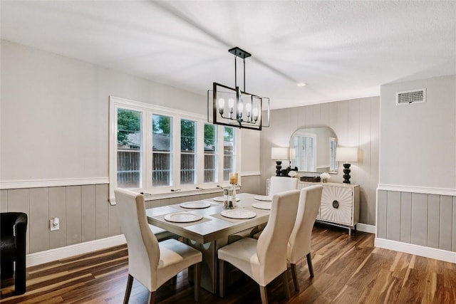 134 Sinclair St, Corpus Christi, TX 78411 - dining space featuring wood finished floors, arched walkways, a chandelier, a decorative wall, and wainscoting