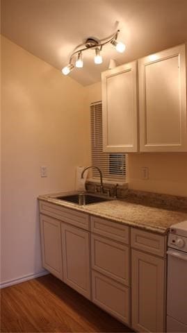 502 Toliver St, Bastrop, TX 78602 - kitchen with wood finished floors, range, and white cabinets