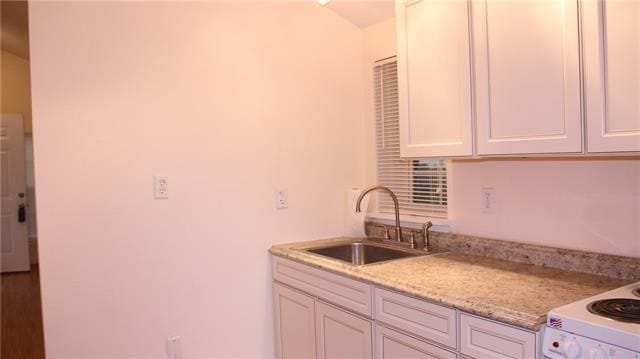 502 Toliver St, Bastrop, TX 78602 - kitchen featuring light stone counters, white cabinetry, and white electric range oven