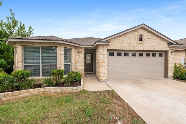 237 Baldwin St, Hutto, TX 78634 - ranch-style house featuring a garage, driveway, stone siding, and roof with shingles