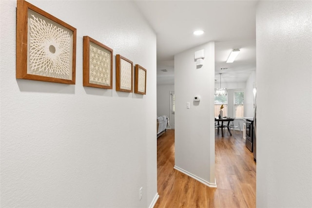 237 Baldwin St, Hutto, TX 78634 - corridor featuring wood finished floors, recessed lighting, and a chandelier