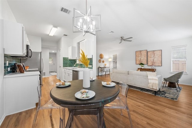237 Baldwin St, Hutto, TX 78634 - dining room featuring light wood finished floors, a ceiling fan, and a chandelier
