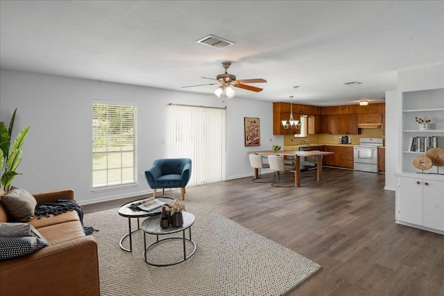 114 Pecan Dr, Elgin, TX 78621 - living room featuring a ceiling fan, dark wood finished floors, and a chandelier