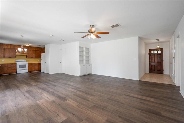 114 Pecan Dr, Elgin, TX 78621 - unfurnished living room featuring a chandelier, dark wood finished floors, and ceiling fan