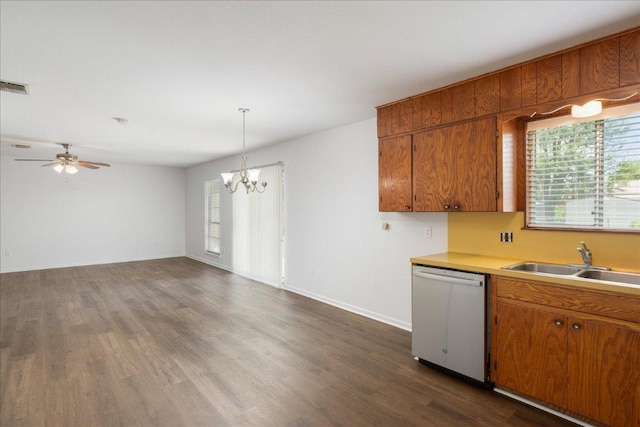 114 Pecan Dr, Elgin, TX 78621 - kitchen with dishwasher, brown cabinets, light countertops, a chandelier, and dark wood-type flooring