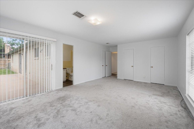 114 Pecan Dr, Elgin, TX 78621 - unfurnished bedroom featuring carpet, multiple closets, and connected bathroom