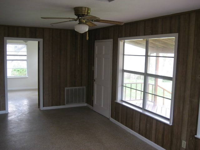 169 Pine Song, Bastrop, TX 78602 - empty room featuring wooden walls, a ceiling fan, and carpet floors