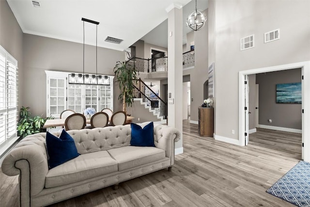 291 Torrington Dr, Austin, TX 78737 - living area with a chandelier, stairs, a towering ceiling, wood finished floors, and crown molding