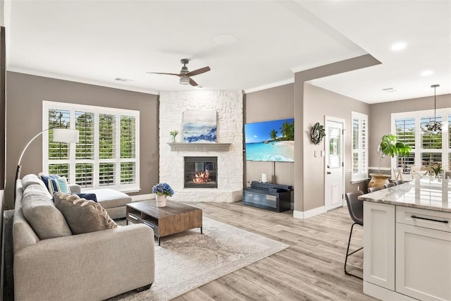 291 Torrington Dr, Austin, TX 78737 - living room featuring a ceiling fan, crown molding, a stone fireplace, light wood-type flooring, and recessed lighting