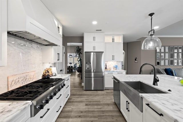 291 Torrington Dr, Austin, TX 78737 - kitchen featuring appliances with stainless steel finishes, premium range hood, decorative backsplash, light stone counters, and white cabinets