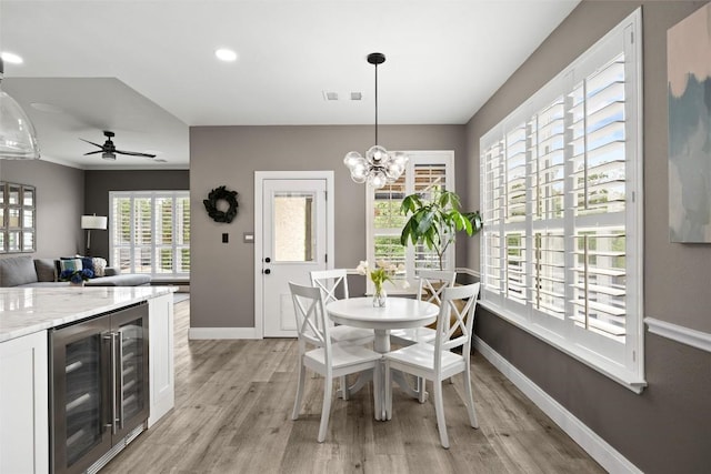 291 Torrington Dr, Austin, TX 78737 - dining area with wine cooler, light wood-style floors, ceiling fan, a chandelier, and recessed lighting