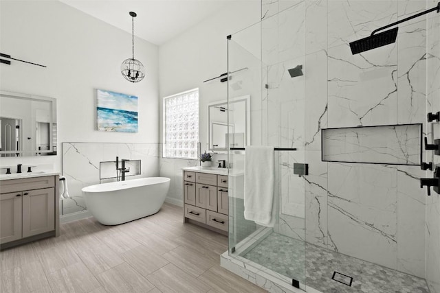 291 Torrington Dr, Austin, TX 78737 - bathroom featuring a marble finish shower, two vanities, a freestanding tub, a chandelier, and tile walls